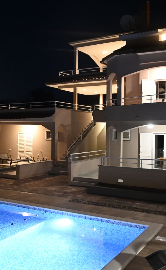 Villa Gehl und beleuchteter Pool am Abend