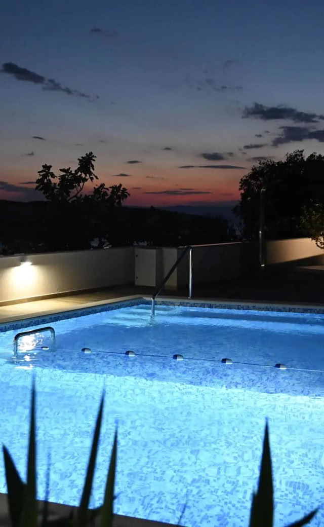 Villa Gehl und beleuchteter Pool am Abend