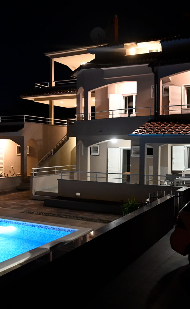 Villa Gehl mit beleuchtetem Pool bei Nacht